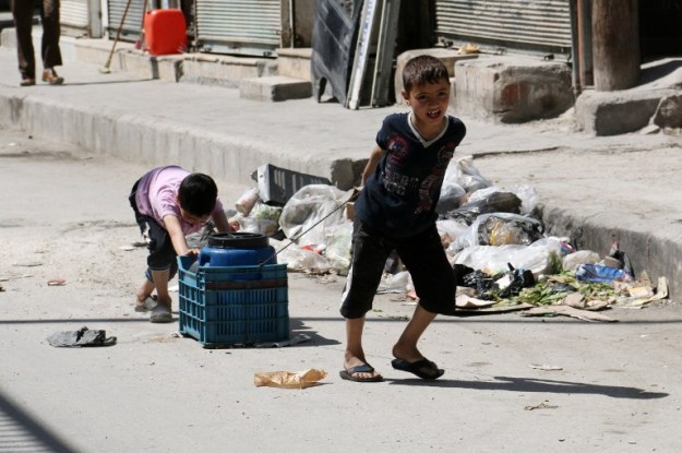 Children carry a cylinder of water in a street of the Syrian city of Aleppo on April 17, 2014. At least 21 people were killed and 50 hurt in a rebel mortar attack on regime-held districts of the Syrian city of Aleppo, a monitoring group said. AFP PHOTO / ALEPPO MEDIA CENTRE / ZEIN AL RIFAI